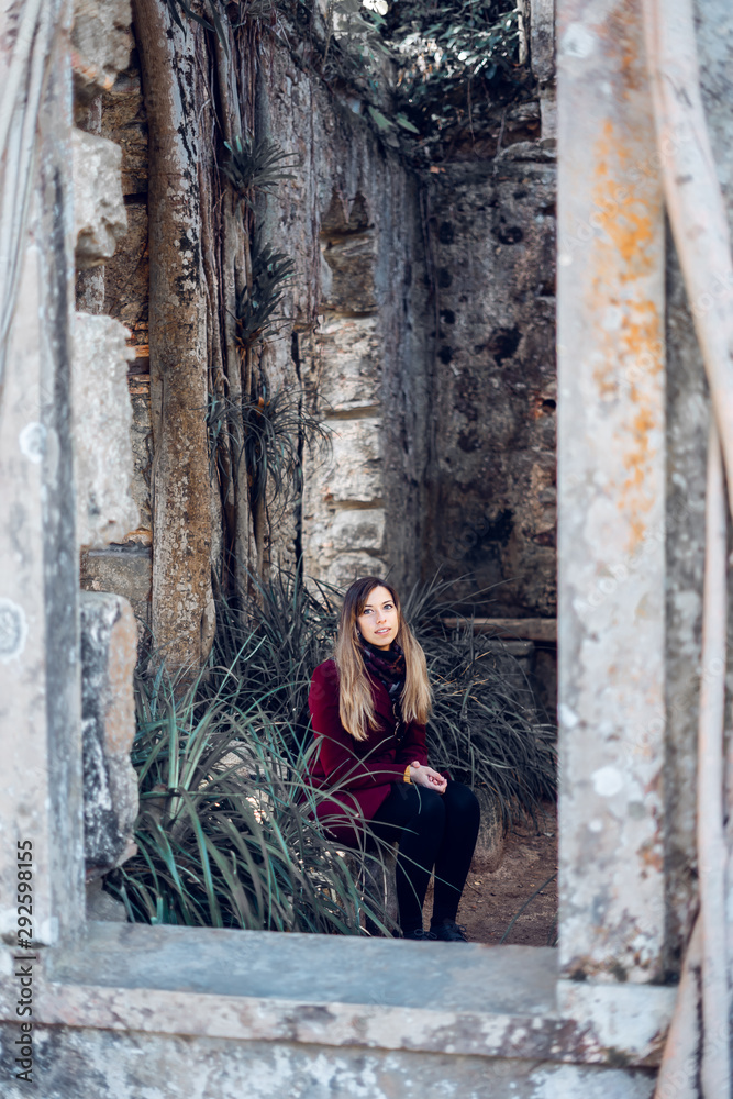 Woman sitting on the ruins of an antique church
