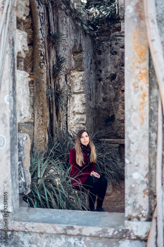 Fototapeta Naklejka Na Ścianę i Meble -  Woman sitting on the ruins of an antique church