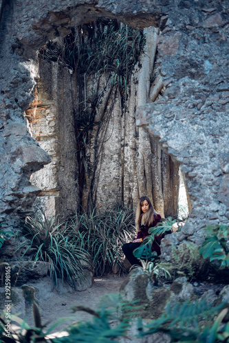 Fototapeta Naklejka Na Ścianę i Meble -  Woman sitting on the ruins of an antique church