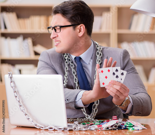 Young businessman addicted to online gambling cards playing in t