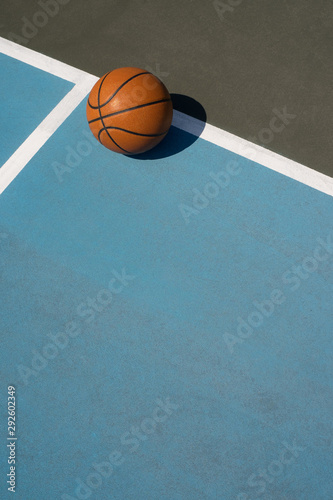 Basketball on outdoor court in sun