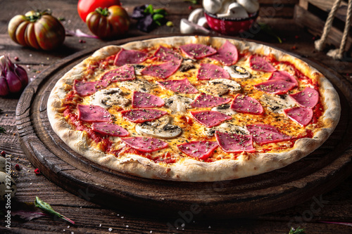 Tasty hot italian pizza Grand with Ham, Mushrooms, Cheddar Cheese, Oregano on old wooden table. Pizzeria menu. Concept poster for Restaurants or pizzerias