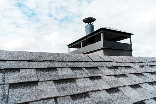 Fototapeta selective focus of modern chimney on rooftop of house
