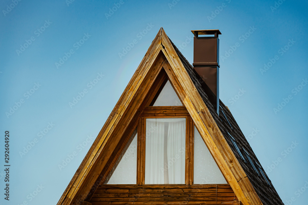 Triangle shape wooden building with a blue sky background. Triangle shape wooden building with a blue sky background.