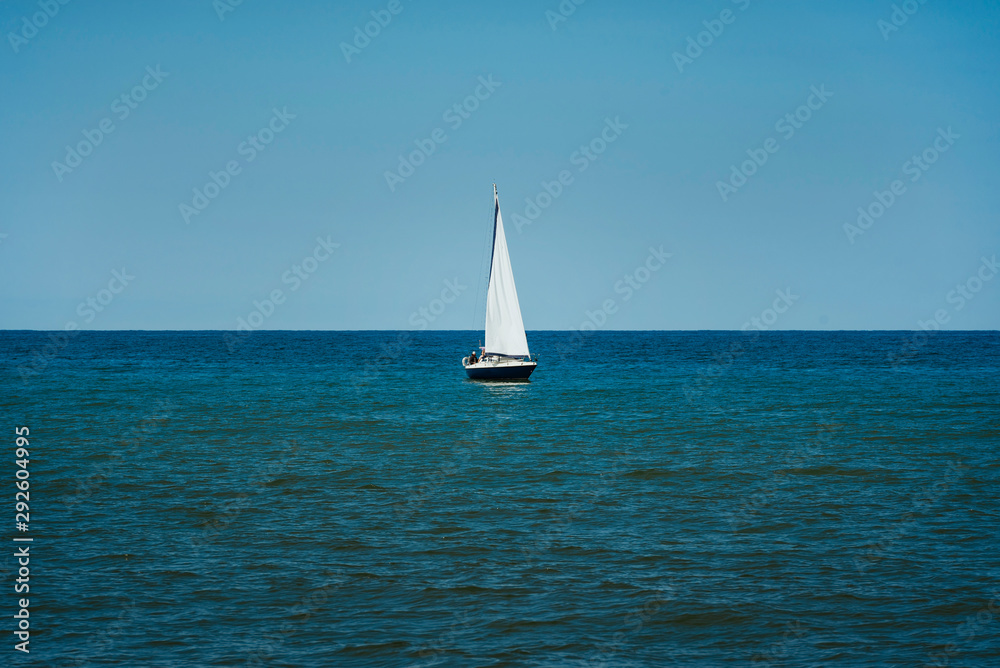 Small yacht in the sea before entering port on sunny summer day.
