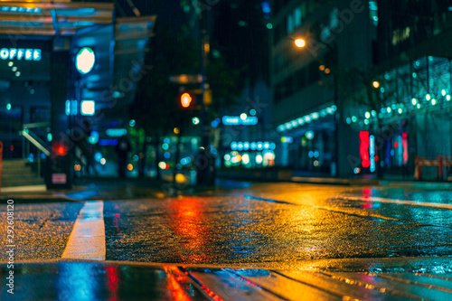 Wet street in downtown Vancouver British Colombia Canada with reflections of orange, red and blue