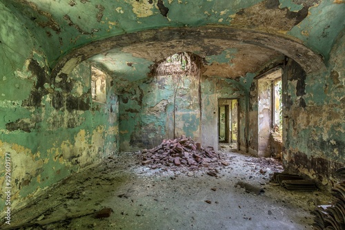 Print op canvas Interior shot of an abandoned building interior with green walls and collapsed c