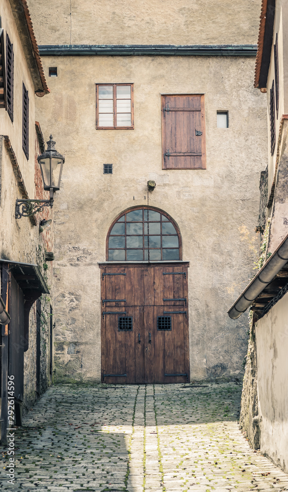 Fototapeta premium Old european wooden door down the alleyway