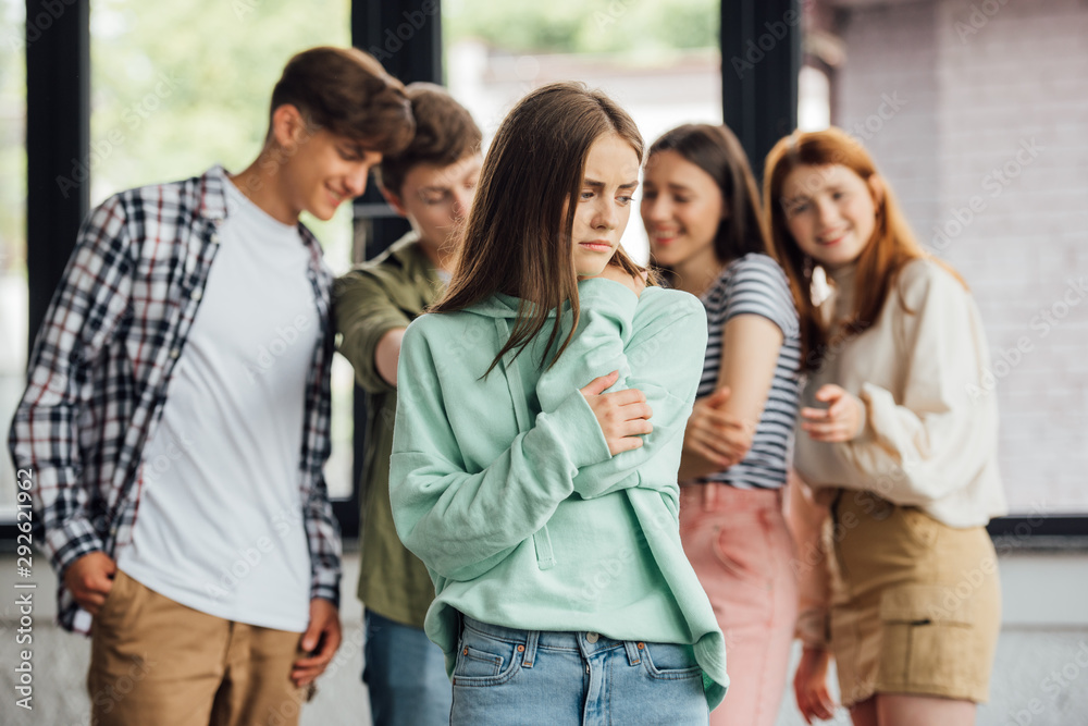 panoramic shot of group of teenagers bullying girl