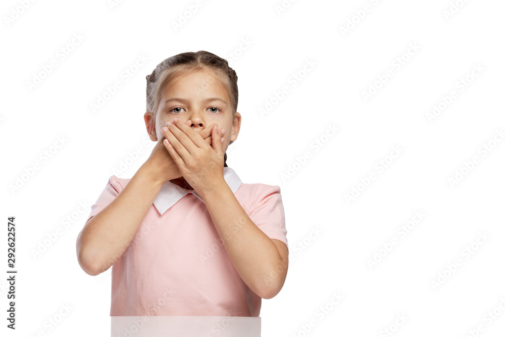 The little girl covered her mouth with her hands. Isolated over white background. The little girl covered her mouth with her hands. Isolated over white background.