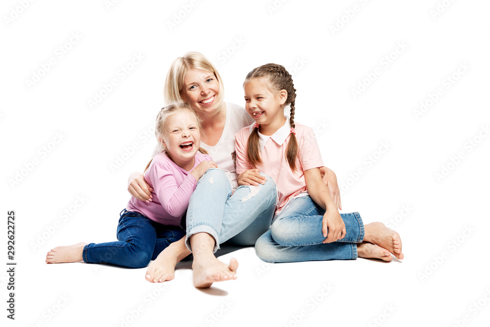 Mom and daughters are sitting and laughing. Love and tenderness. Isolated over white background. Mom and daughters are sitting and laughing. Love and tenderness. Isolated over white background.