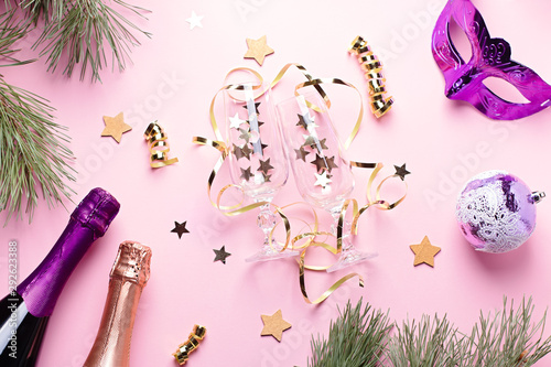 Christmas card with champagne bottles, glasses, carnival mask, ornaments in pink and purple colors