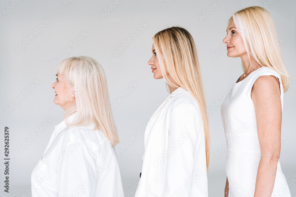 side view of beautiful three generation blonde women isolated on grey side view of beautiful three generation blonde women isolated on grey