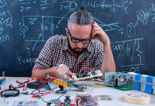 Focused and hard thinking technician working on electric devices