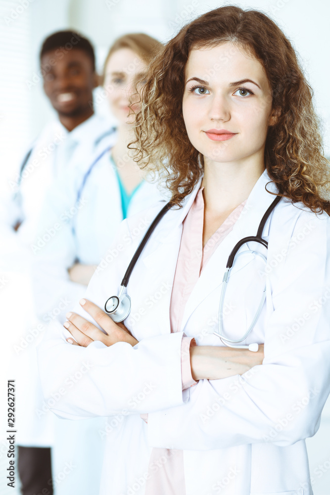 Happy doctor woman with medical staff at the hospital. Multi ethnic people group Happy doctor woman with medical staff at the hospital. Multi ethnic people group