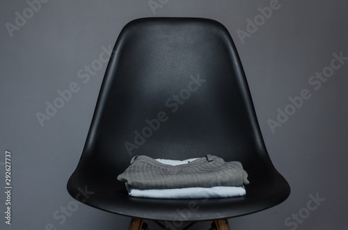 black chair with a stack of clothes photo