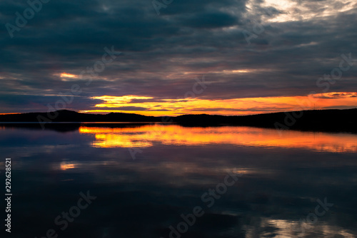 Water reflections at midnight sun at serene lake in finlandd © tommitt