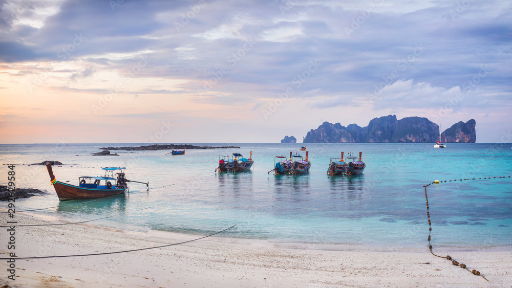 Tropical sandy beach with wooden boats on foreground - Phi-Phi island Long beach panorama, Krabi Province, Thailand Tropical sandy beach with wooden boats on foreground - Phi-Phi island Long beach panorama, Krabi Province, Thailand