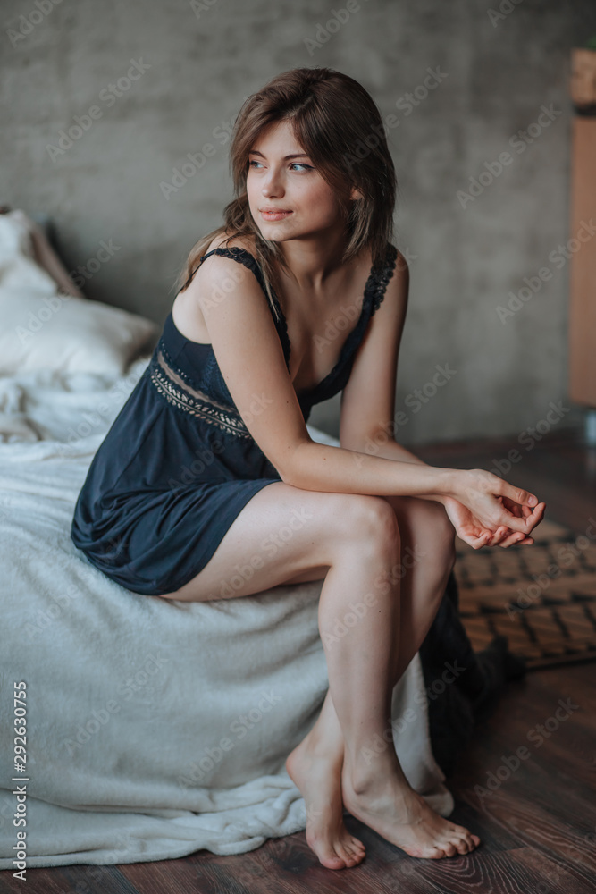 Girl with beautiful legs sitting on the bed Stock Photo