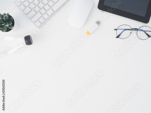 top view of office desk table with notebook, plastic plant, digital camera and keyboard on white background, graphic designer, Creative Designer concept.