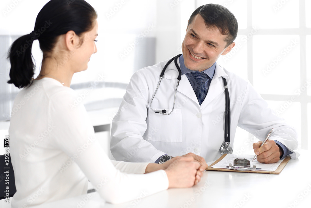 Doctor and patient discussing medical exam resoults at hospital office. Physician using clipboard for filling up medication history records. Perfect medical service in clinic. Medicine and healthcare Doctor and patient discussing medical exam resoults at hospital office. Physician using clipboard for filling up medication history records. Perfect medical service in clinic. Medicine and healthcare