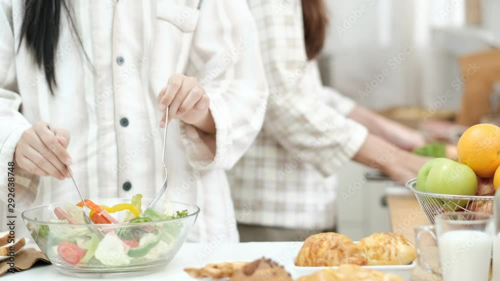 Two sisters with nightdress help each other to cook or prepare salad of fruit and vegetable in kitchen. Two sisters with nightdress help each other to cook or prepare salad of fruit and vegetable in kitchen.