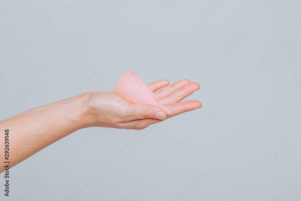 Close up of woman hand holding menstrual cup Close up of woman hand holding menstrual cup