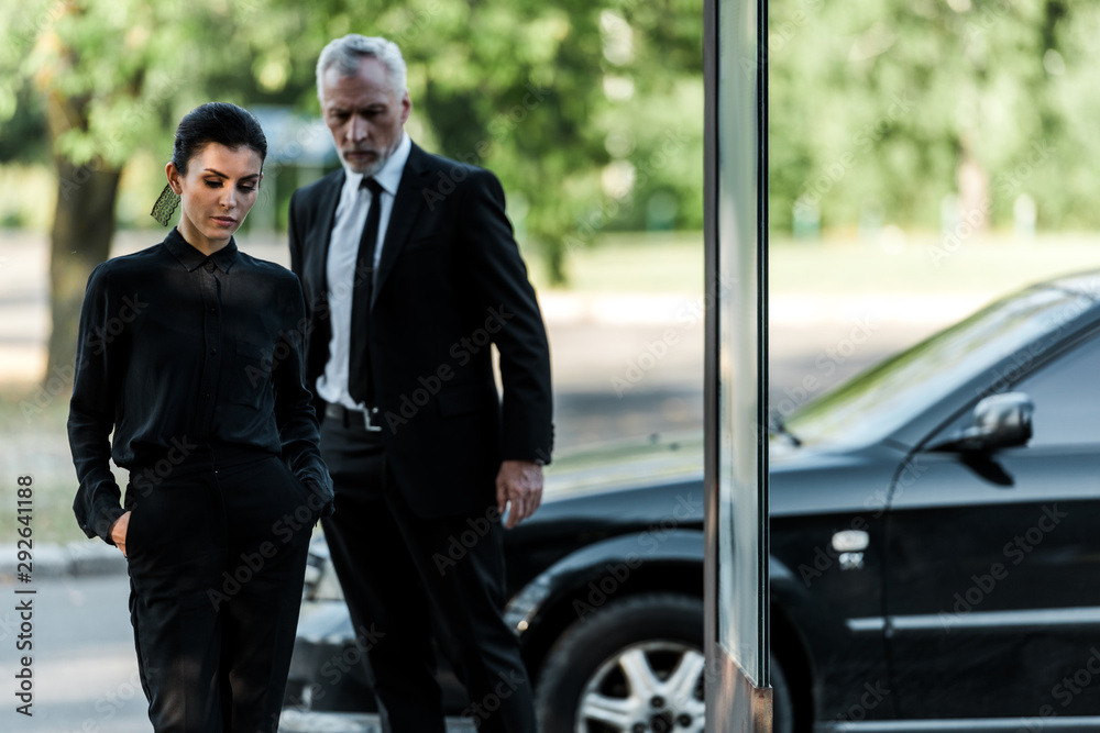 upset senior man and sad woman in formal wear near car upset senior man and sad woman in formal wear near car