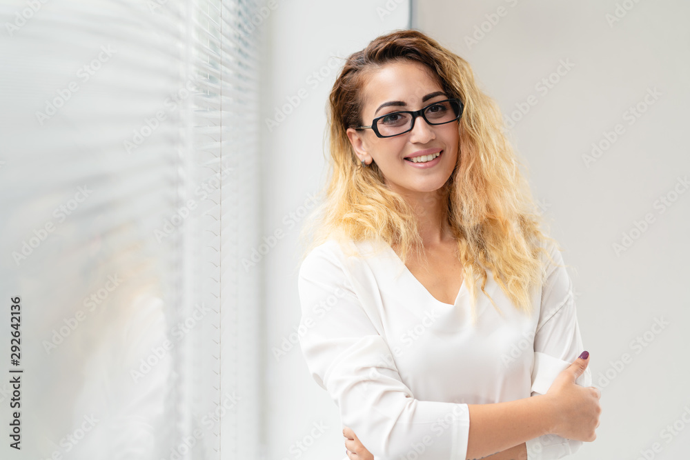 Happy pretty young woman with glasses in office
