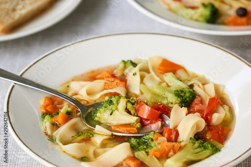 Soup with fresh vegetables and noodles in a white bowl 
