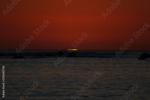 sun reaching the horizon in the sea on a red sky sunset © Marcos