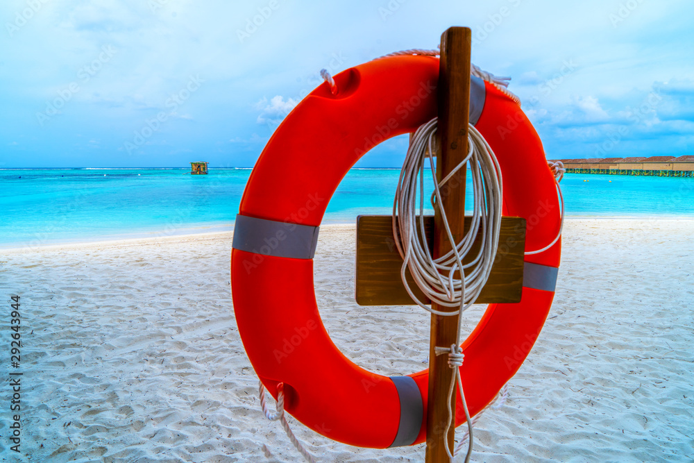 A lifebuoy on a paradise beach with a blue ocean in the backgrou