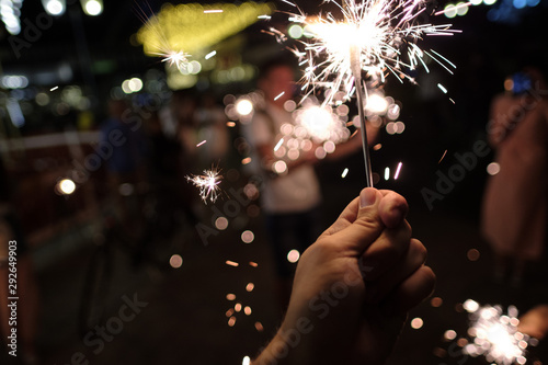 Hand with Sparkler. blurry sparks and background