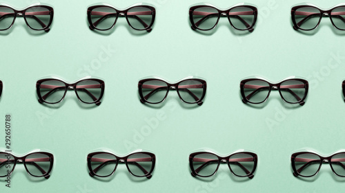 Trendy summer pattern made with fashion sunglasses on bright light mint background. Minimal style with colorful paper backdrop. Colorful photo. Minimal creative concept. Pastel colors. Neo mint