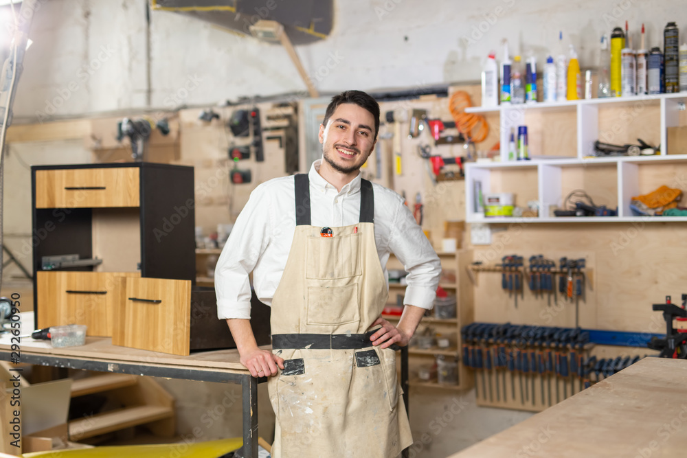 furniture factory, Small-Sized Companies and people concept - Portrait of a smiling male worker at manufacturing furniture factory, Small-Sized Companies and people concept - Portrait of a smiling male worker at manufacturing