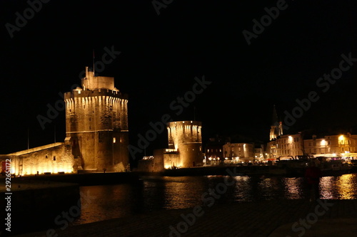La Rochelle old port (Vieux Port) lit up at night, showing Tour Saint Nicholas (on the left) and Tour de la Chaine (on the right) guarding the entrance to the harbour