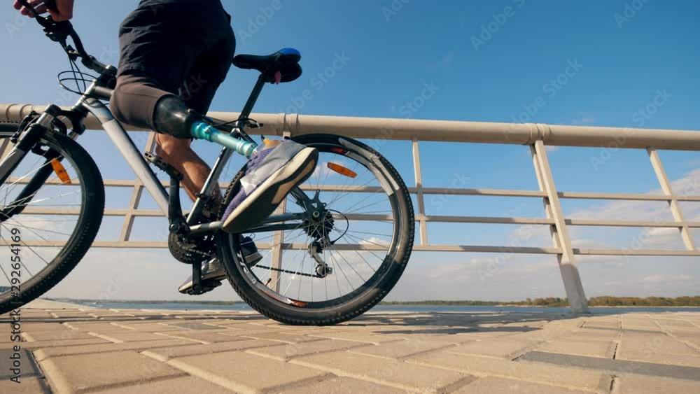Athlete with a prosthetic leg is getting on a bike