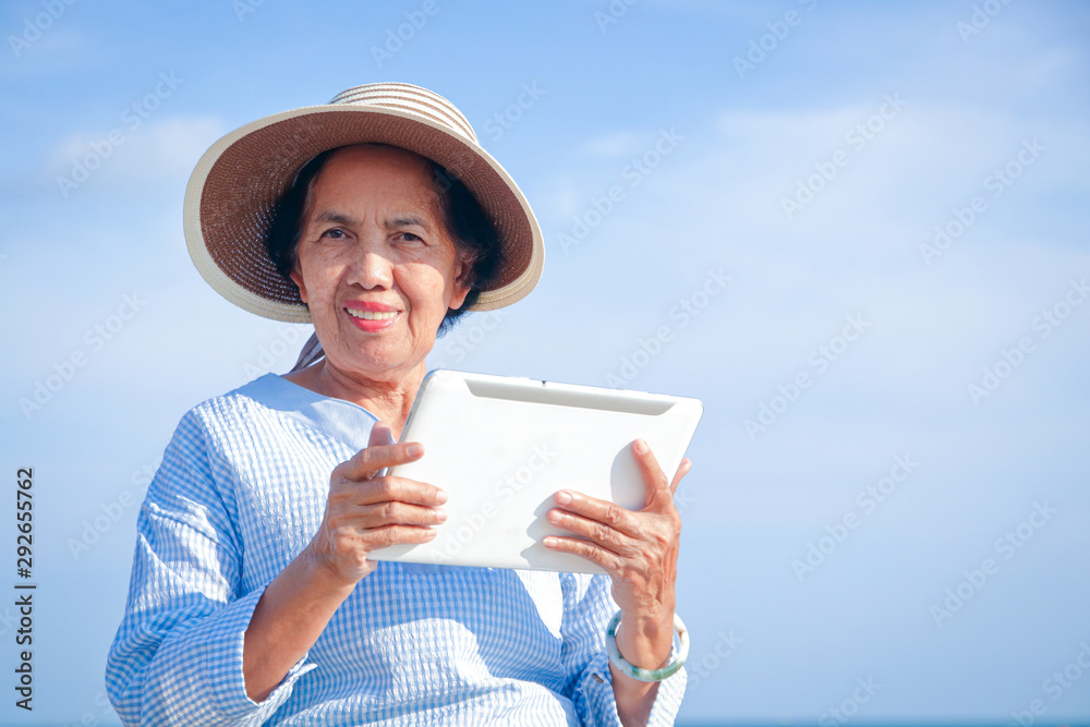 Fototapeta premium Elderly women hold intelligent tablet communication devices for video chatting, talking with their children. Happy retirement concept