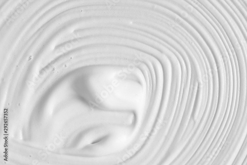 White cosmetic foam texture background. Cosmetic mousse, cleanser, shaving foam, shampoo. Foamy skin care product swirl