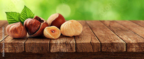 Nuts on wooden table and nature in background photo