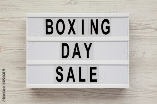 'Boxing day sale' words on a modern board on a white wooden surface, top view. Overhead, from above, flat lay.