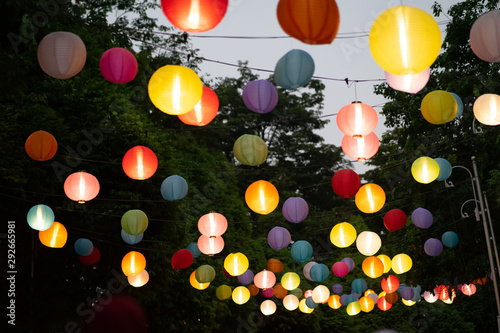 Colourful Paper Lantern hanging with trees and sky in the background. photo