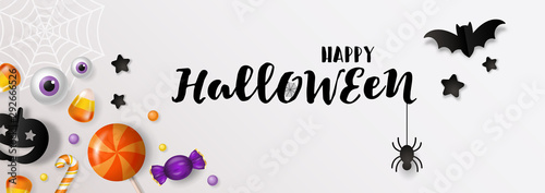 Halloween banner design with candy and paper cut decorations background.