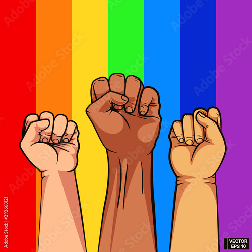 Fist of different color of skin on rainbow background.