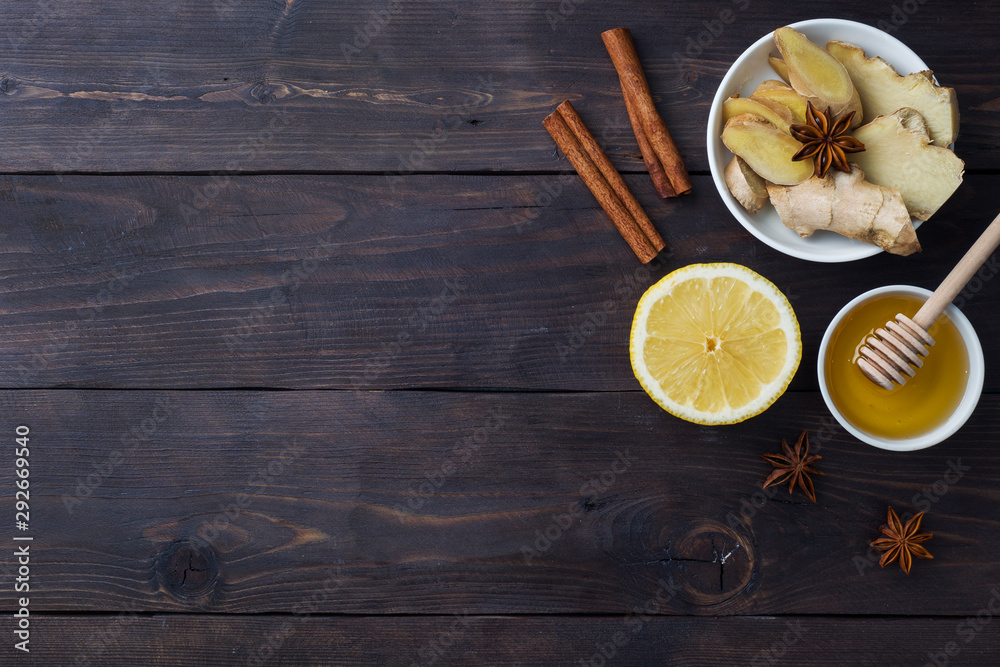 White Cup with natural herbal tea ginger lemon and honey cinnamon. Energy vitamin drink is used for colds.Dark wooden background copy space White Cup with natural herbal tea ginger lemon and honey cinnamon. Energy vitamin drink is used for colds.Dark wooden background copy space