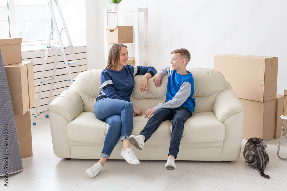 Satisfied happy caucasian single mother and son happily communicate discussing the design of the new apartment during the housewarming party with their scottish fold cat. Satisfied happy caucasian single mother and son happily communicate discussing the design of the new apartment during the housewarming party with their scottish fold cat.