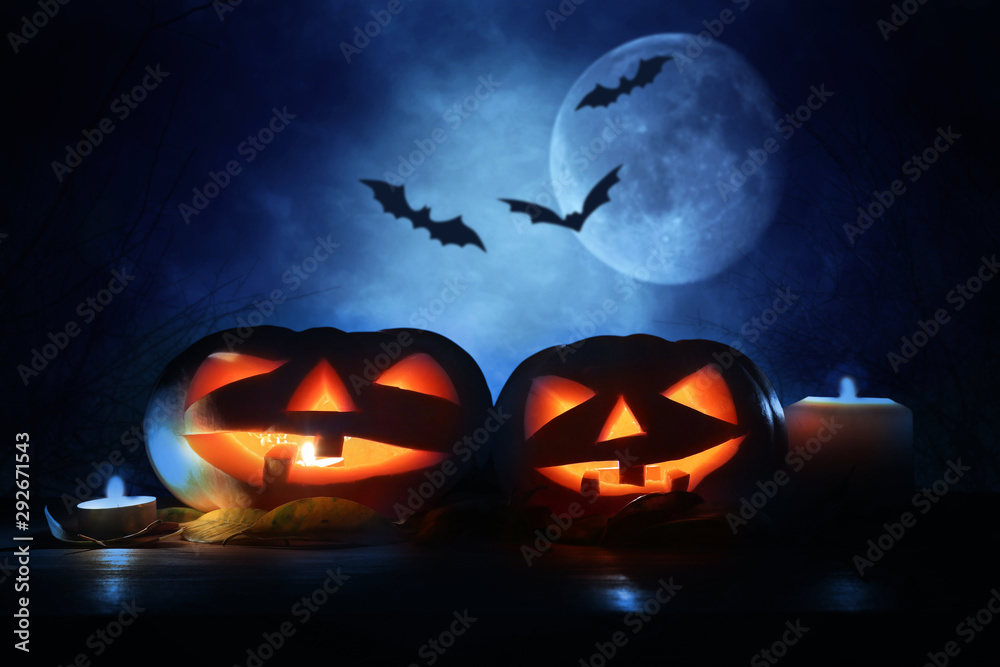 holidays concept of Halloween . Pumpkins over wooden table at night scary, haunted and misty forest holidays concept of Halloween . Pumpkins over wooden table at night scary, haunted and misty forest