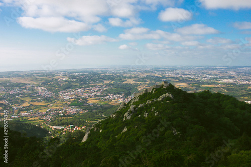 Cloudy view on the hill and portuguese town with green landscape
