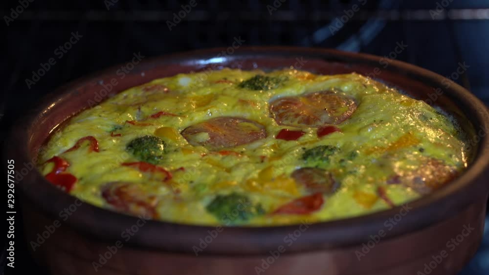 Ceramic bowl with vegetable frittata, simple vegetarian food. Frittata with egg, tomato, pepper, onion, broccoli and cheese , close up. Italian egg omelette in oven Ceramic bowl with vegetable frittata, simple vegetarian food. Frittata with egg, tomato, pepper, onion, broccoli and cheese , close up. Italian egg omelette in oven