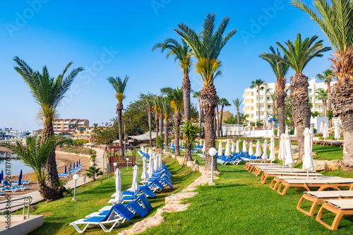 Cyprus. Protaras. Pernera. Kalamies Beach. Beach holidays on the Mediterranean coast. Hotels near the coastline. Beach is empty. Palm trees, sunbeds and umbrellas on the Mediterranean coast. photo